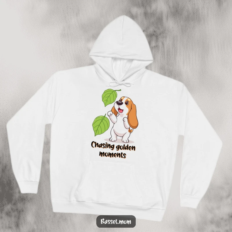Funny Basset Hound hoodie, showing a dog joyfully attempting to catch a huge falling leaf, perfect for cozy autumn days.