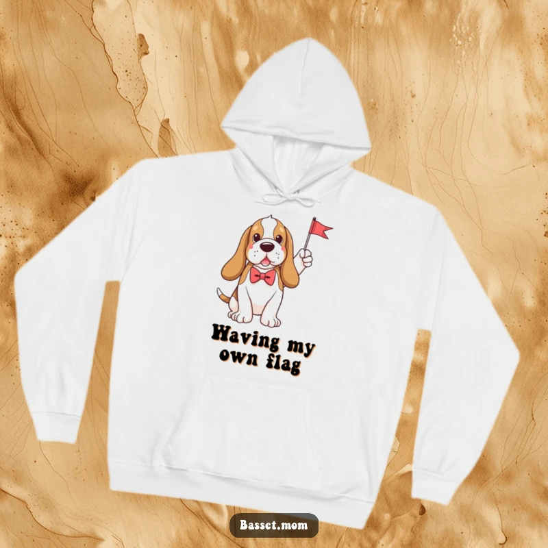 Funny plush Basset Hound wearing a smart bow tie cheerfully waves a miniature flag, bringing cozy humor to this warm hoodie.