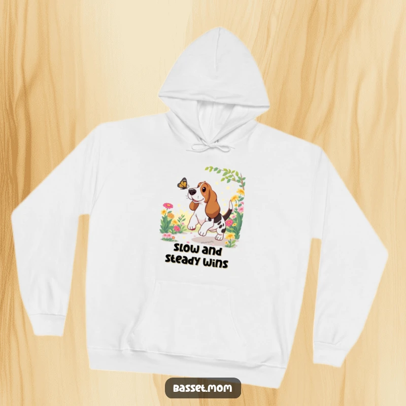 Funny Basset Hound Hoodie: A joyful dog happily pursues a butterfly in a bright, sun-drenched garden.