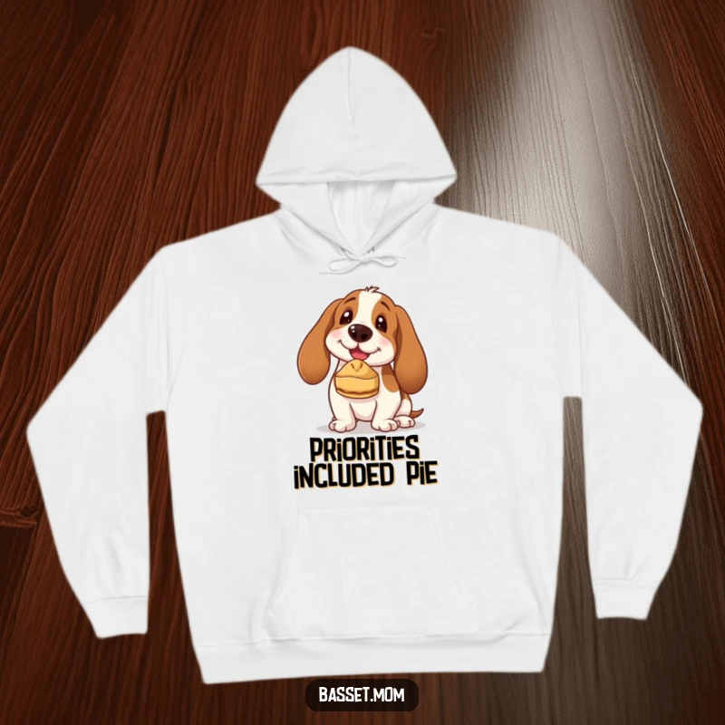 Funny Basset Hound hoodie featuring a joyful dog balancing a miniature pie on its nose, looking incredibly proud of its silly accomplishment.