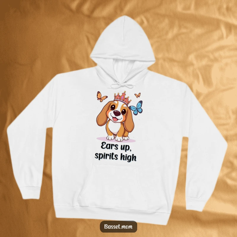 Funny Basset Hound hoodie showcasing a crowned dog gleefully pursuing a butterfly, offering warmth and a hefty dose of whimsical charm.