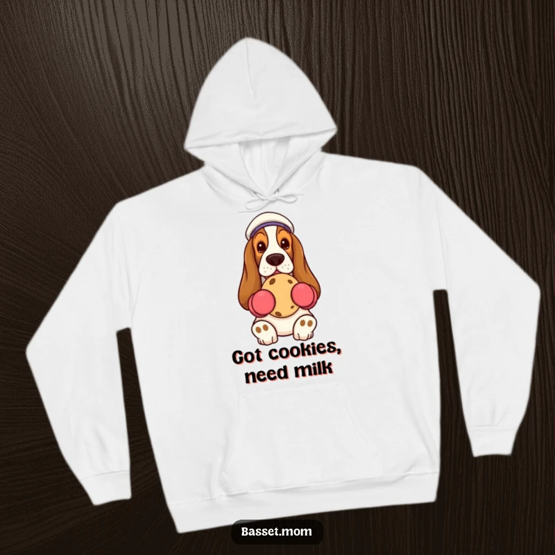 Funny Basset Hound wearing oven mitts, holding a cookie, soft hooded sweatshirt, humorous pet gift.
