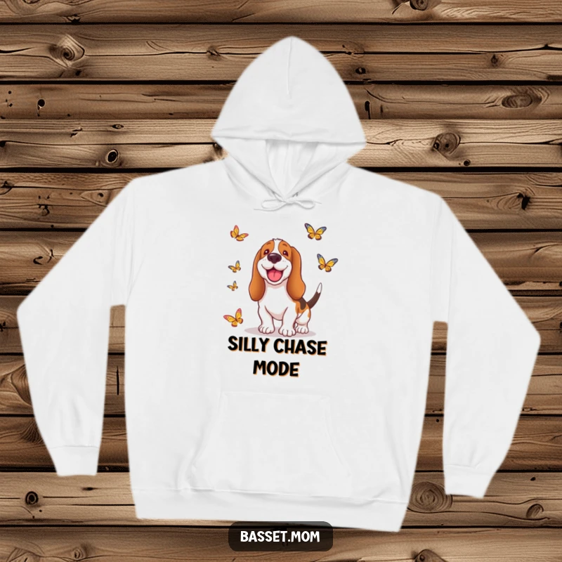 Funny Basset Hound hoodie featuring a dog with a wide, silly grin, playfully chasing butterflies through a sunlit field, radiating happiness.
