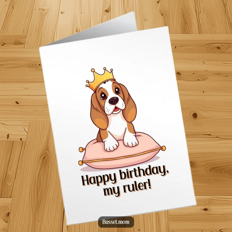 Funny free printable birthday card featuring a Basset Hound wearing a tiny crown, looking regal while perched on a cushion.