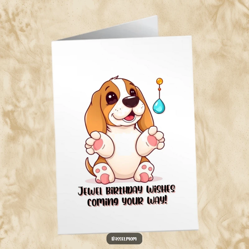 Funny Free Printable Birthday Card: A Basset Hound with paws up, playfully batting at a shiny dangling jewel for a birthday.