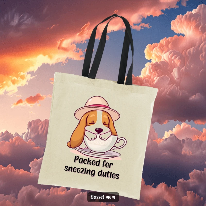 Funny Basset Hound tote bag depicting a hound in a large hat, sleeping peacefully by a teacup, great for carrying essentials with humor.